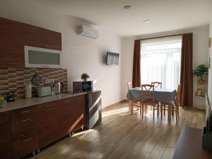 a kitchen with a table and a dining room at Strand Vendégház in Poroszló