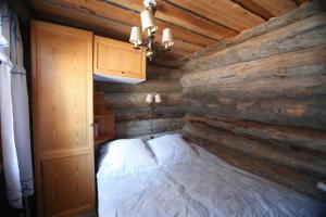 una camera da letto con un letto e una parete in legno di VIP Luostonkehto, Wi-Fi, ilmastointi a Luosto