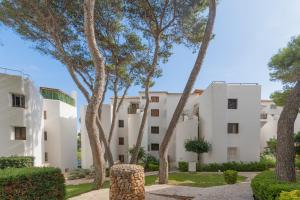 a building with palm trees in front of it at Apartamento Ferrera Park 103 in Cala d´Or