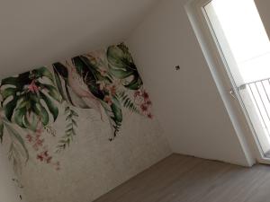 巴爾多利諾的住宿－Hotel Orchidea，墙上装饰有花卉壁画的房间