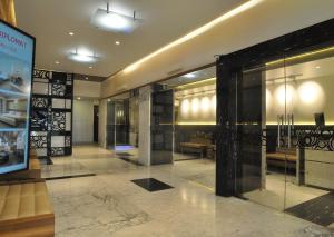 a lobby with glass doors and benches in a building at Hotel Diplomat, Colaba in Mumbai