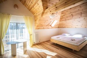 sypialnia z łóżkiem i drewnianym sufitem w obiekcie Grand Villla Skyta w mieście Worochta