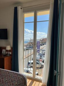 a room with a balcony with a view of a parking lot at Hôtel Posta Vecchia in Bastia