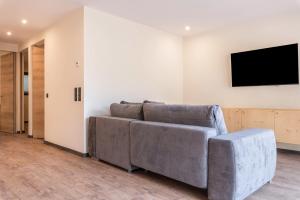 ein Wohnzimmer mit einem Sofa und einem Flachbild-TV in der Unterkunft Villa Lara Föhre in Kastelruth