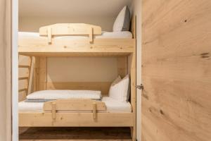 2 Etagenbetten in einem kleinen Zimmer mit einer Tür in der Unterkunft Villa Lara Föhre in Kastelruth