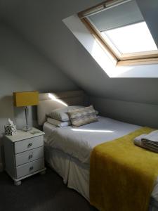 a attic bedroom with two beds and a skylight at York City Homestays in York