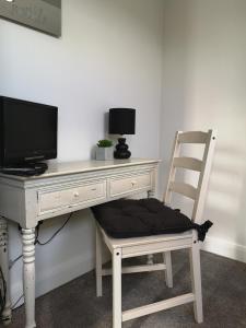 a chair sitting in front of a desk with a computer at York City Homestays in York