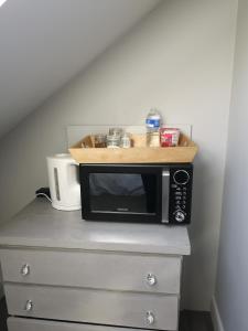 a microwave sitting on top of a dresser at York City Homestays in York