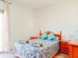a bedroom with a bed with blue pillows on it at Apartamento Vista a la Isla in Carboneras