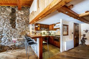a kitchen with wooden cabinets and a stone wall at Arpy an in Morgex