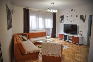 un soggiorno con un divano e un orologio a parete di Apartman Dado a Sombor