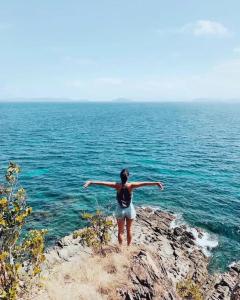 a woman standing on a cliff overlooking the ocean at ISLA tress Bonita Wellness Escape Island in San Vicente