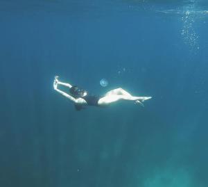 a woman swimming in the water in the ocean at ISLA tress Bonita Wellness Escape Island in San Vicente