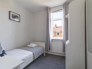 a small bedroom with a bed and a window at Lily Apartment 2-Remarkable 2 Bed Bedlington in Bedlington