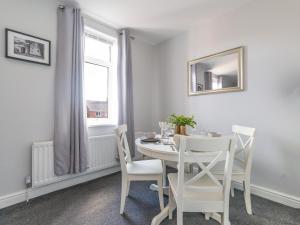 Lily Apartment 2-Remarkable 2 Bed Bedlington في Bedlington: غرفة طعام بيضاء مع طاولة بيضاء وكراسي