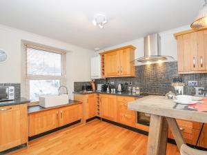 a kitchen with wooden cabinets and a wooden table at Sea View in St Austell
