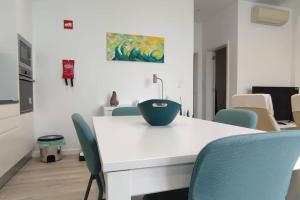 a white table with chairs and a bowl on it at Casa do Ilhéu in Vila Franca do Campo