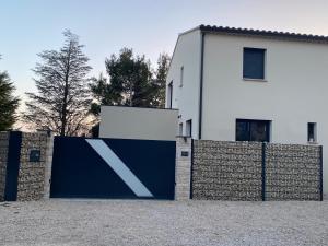ein blauer Zaun vor einem weißen Haus in der Unterkunft Luxury House Family’s in Carpentras