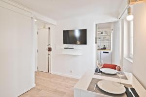 sala de estar con mesa y TV en la pared en BmyGuest - Alfama 1 Apartment en Lisboa