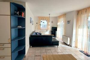 a living room with a black couch and blue shelves at Am Strand 2, PP innen in Zingst