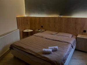 ein Schlafzimmer mit einem großen Bett mit zwei Handtüchern darauf in der Unterkunft Hotel Lido in Pristina
