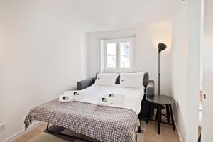 1 dormitorio con 1 cama con sábanas blancas y mesa en BmyGuest - Alfama 1 Apartment en Lisboa
