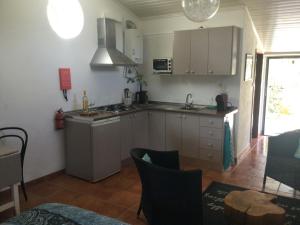 a kitchen with white cabinets and a table in a room at Flor da Ramila in Marvão