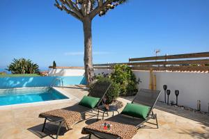 un patio con 2 sillas y una piscina en Casa Paraíso en Puerto de la Cruz