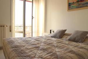 a bedroom with a large bed with a large window at VI Floor Apartment in Rome