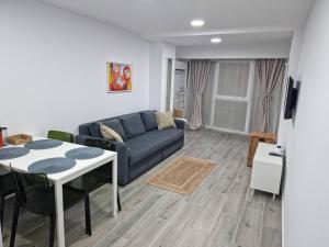 sala de estar con sofá azul y mesa en Sea View Apartments Olimp- The sunny apartment, en Olimp