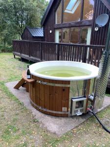 Un grand bain à remous est installé à l'extérieur de la maison. dans l'établissement Loch Aweside Forest Cabins, à Dallavich