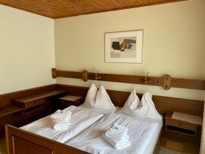 Schlafzimmer mit einem Bett mit weißer Bettwäsche und Kissen in der Unterkunft Hof zur Steinwänd in Micheldorf in Oberösterreich