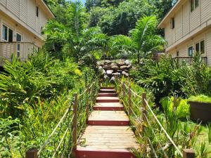 a wooden walkway leading to a building with plants at Hôtel Hamaha Beach in Mamoudzou