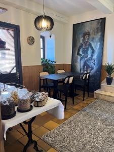 a dining room with tables and a painting of a soldier at Hôtel Posta Vecchia in Bastia