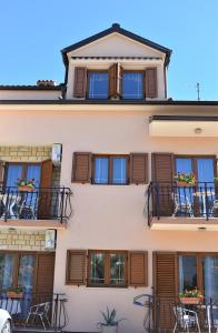un edificio con ventanas y balcones con mesas y sillas en Apartments & Rooms Ivana, en Rovinj