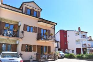 un edificio con balconi e auto parcheggiate in un parcheggio di Apartments & Rooms Ivana a Rovigno (Rovinj)
