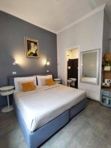 una camera da letto con un grande letto bianco con cuscini gialli di Hotel Castelfidardo a Roma