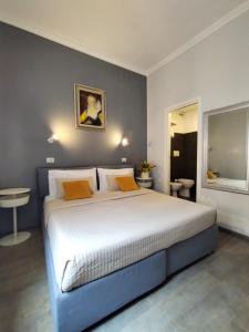 ein Schlafzimmer mit einem großen weißen Bett mit orangefarbenen Kissen in der Unterkunft Hotel Castelfidardo in Rom