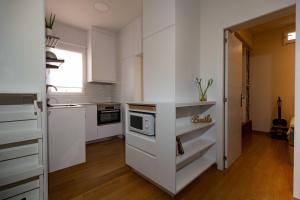 a kitchen with white cabinets and a microwave at De El Retiro al cielo in Madrid