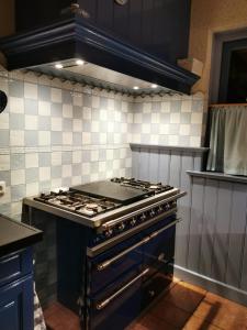 a kitchen with a stove top oven in a kitchen at Holiday home bos en heide in Otterlo