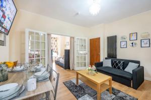 a living room with a black couch and a table at *1va* ground floor apartment setup for your most amazing & relaxed stay + Free Parking + Free Fast WiFi * in Killingbeck