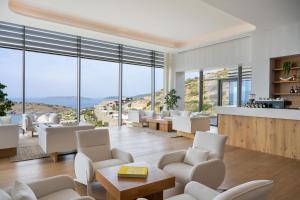 a living room with white furniture and large windows at METT Hotel & Beach Resort Bodrum in Bodrum City