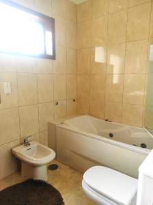 a bathroom with a tub and a toilet and a sink at Casa T4 perto da Praia in Fão