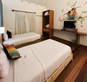 a room with two beds and a tv in it at Usgar San Pedro Boutique in Cusco