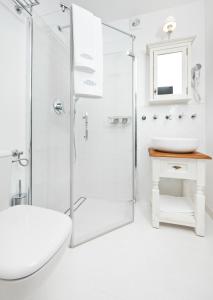 a white bathroom with a shower and a sink at Villa Polanica in Polanica-Zdrój