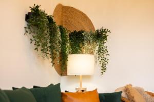 a table with a lamp and a plant on a wall at Peaceful Returns - 2 Bed House Near Roundhay Park in Leeds