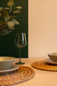 a glass of wine sitting on a table with two bowls at Peaceful Returns - 2 Bed House Near Roundhay Park in Leeds