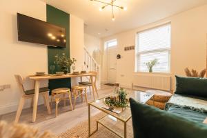 een woonkamer met een bank en een tafel bij Peaceful Returns - 2 Bed House Near Roundhay Park in Leeds