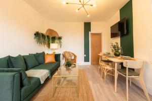 een woonkamer met een groene bank en een tafel bij Peaceful Returns - 2 Bed House Near Roundhay Park in Leeds
