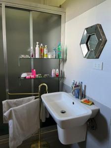 uma casa de banho com um lavatório branco e um espelho. em Precious J Residence 